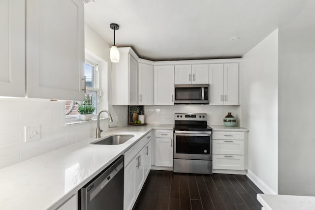 kitchen with pendant lighting, white cabinetry, sink, and stainless steel appliances