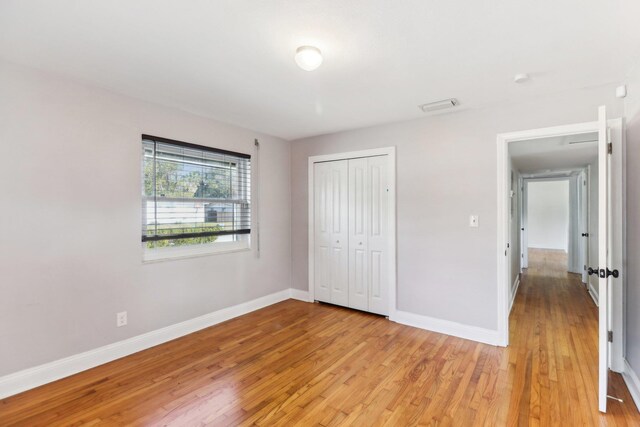 unfurnished bedroom with a closet and light hardwood / wood-style floors