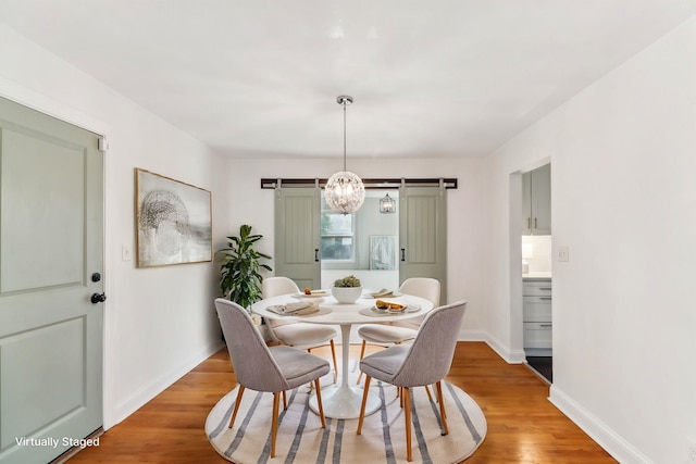 dining area featuring a barn door and hardwood / wood-style flooring