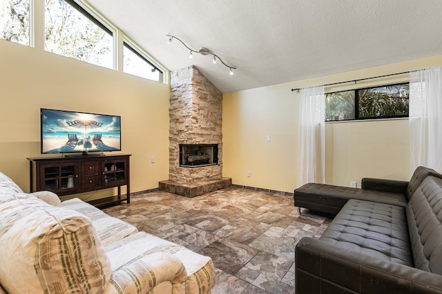 living room with a stone fireplace, high vaulted ceiling, and a textured ceiling