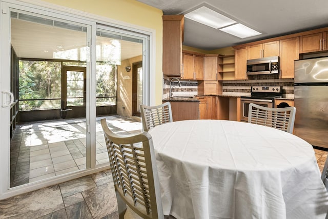 kitchen with backsplash, stainless steel appliances, and sink