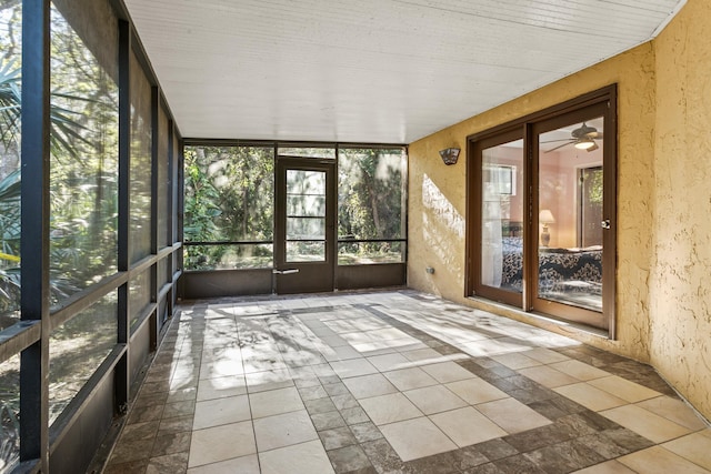 unfurnished sunroom featuring ceiling fan