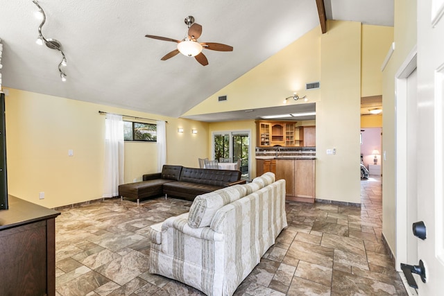 living room featuring beam ceiling, a textured ceiling, high vaulted ceiling, and ceiling fan