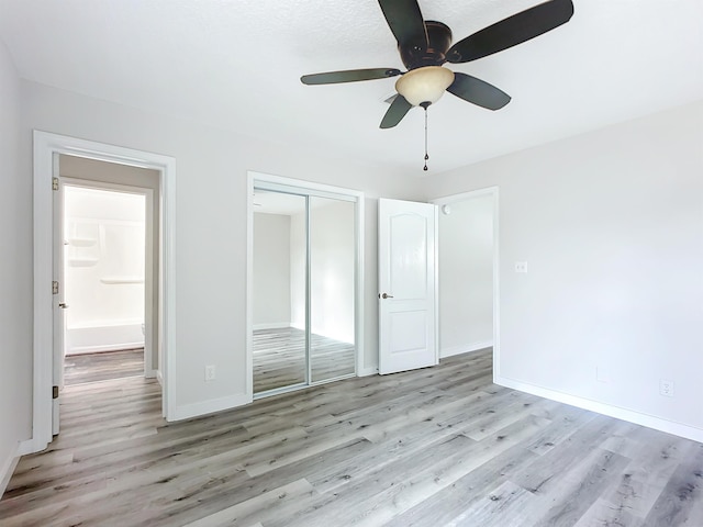 unfurnished bedroom with ceiling fan, a closet, wood finished floors, and baseboards