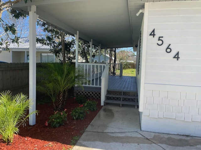 exterior space featuring covered porch and fence