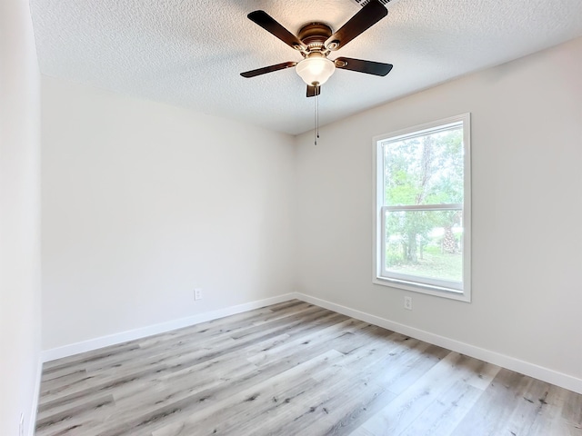 unfurnished room featuring a ceiling fan, light wood-style flooring, baseboards, and a textured ceiling