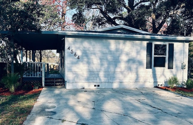 view of side of property featuring concrete driveway