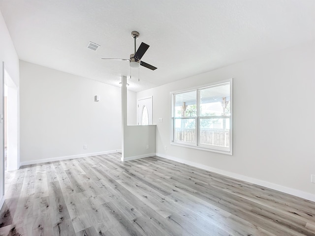 spare room featuring a ceiling fan, baseboards, visible vents, and light wood finished floors