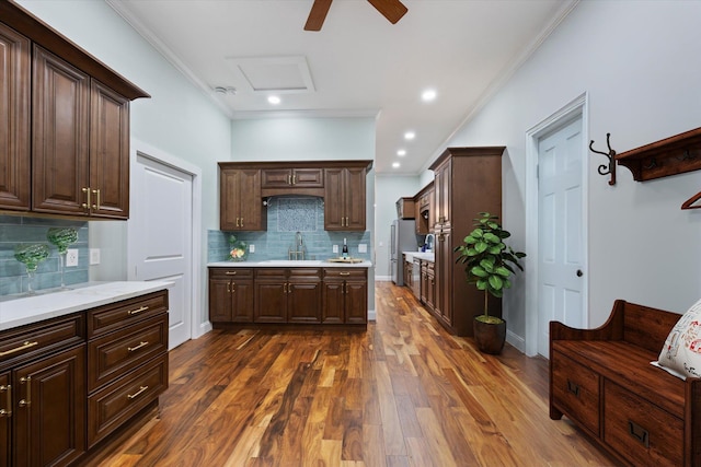 3943 NW 219th St, Rdd, Micanopy, FL 32667 - kitchen featuring ornamental molding, dark brown cabinets, tasteful backsplash, dark wood-style flooring, and ceiling fan