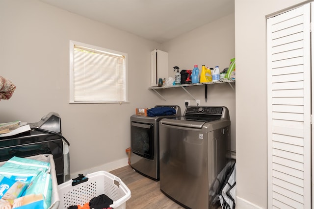 clothes washing area with light wood-type flooring and independent washer and dryer