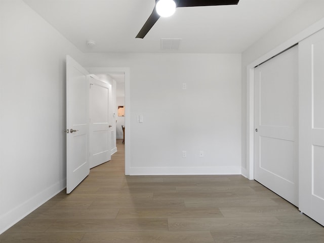 unfurnished bedroom featuring a closet, ceiling fan, and light hardwood / wood-style flooring