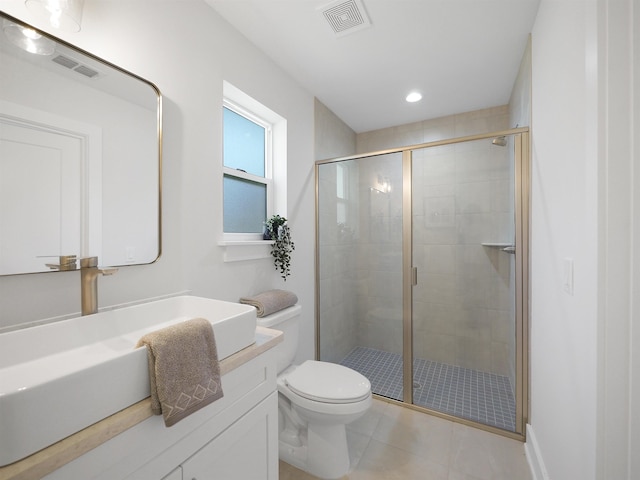 bathroom featuring a shower with door, vanity, tile patterned floors, and toilet