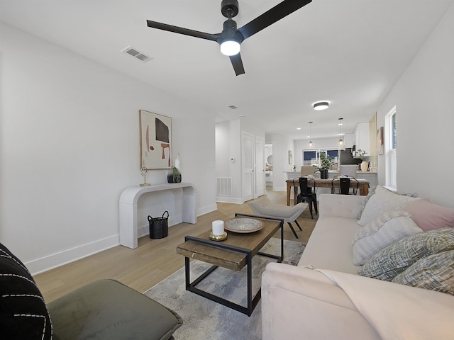 living room with ceiling fan and light wood-type flooring