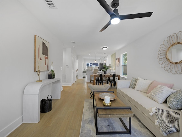 living room with ceiling fan and light wood-type flooring