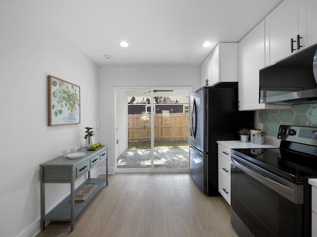 kitchen with stainless steel appliances, light hardwood / wood-style floors, decorative backsplash, and white cabinets