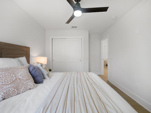 bedroom featuring hardwood / wood-style floors, a closet, and ceiling fan