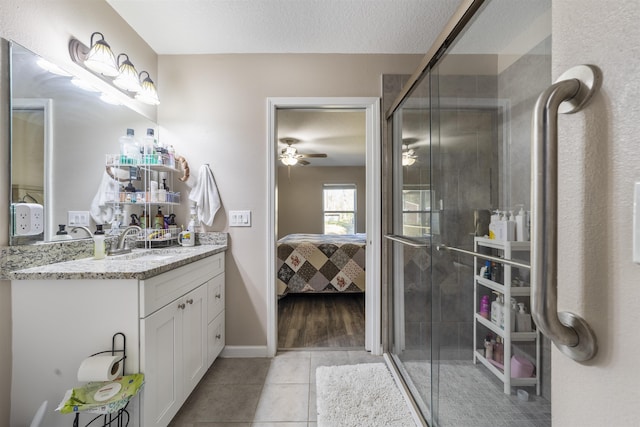 bathroom featuring tile patterned floors, an enclosed shower, a textured ceiling, vanity, and ceiling fan