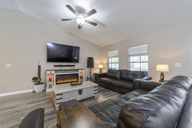 living room with a textured ceiling, dark hardwood / wood-style floors, vaulted ceiling, and ceiling fan