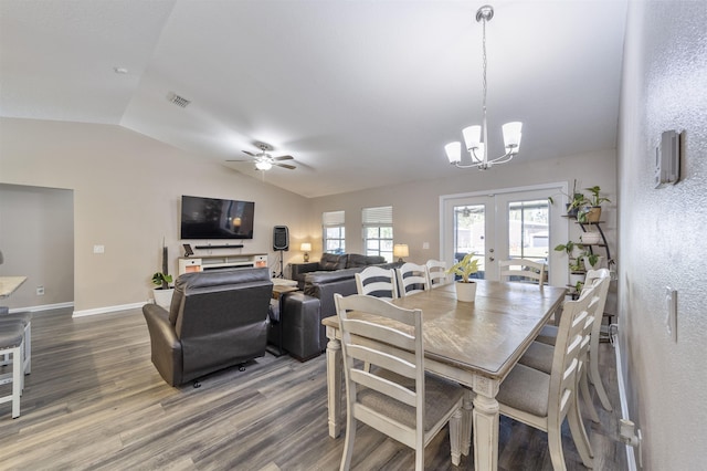 dining area featuring vaulted ceiling, french doors, ceiling fan with notable chandelier, and hardwood / wood-style flooring