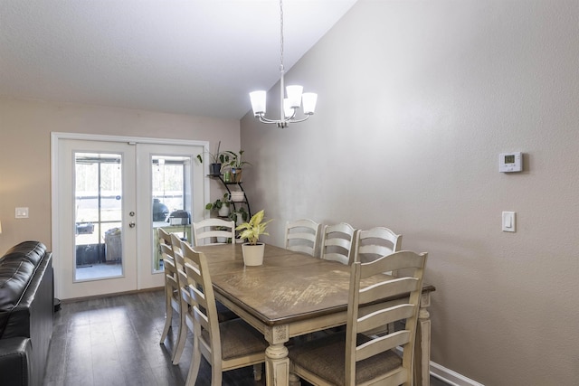 dining space with vaulted ceiling, french doors, dark hardwood / wood-style floors, and a notable chandelier