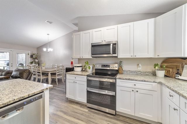 kitchen with white cabinets, lofted ceiling, stainless steel appliances, and french doors