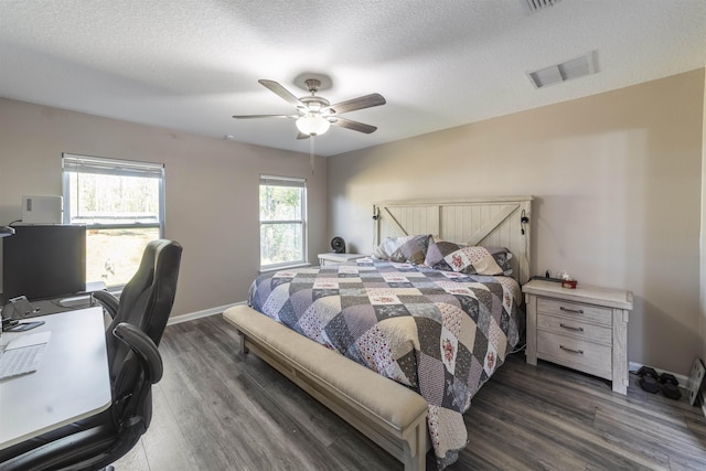 bedroom with ceiling fan, a textured ceiling, and dark wood-type flooring