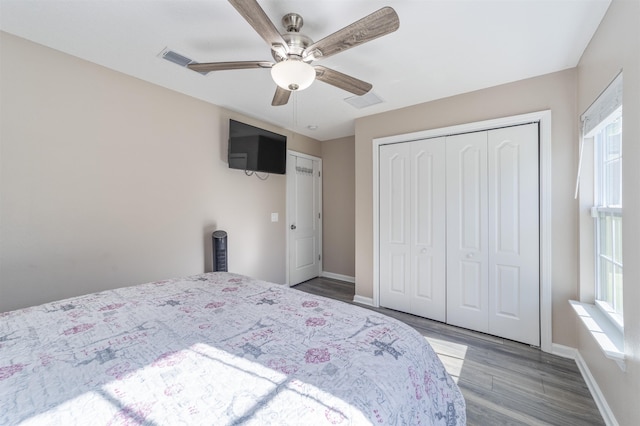 bedroom with hardwood / wood-style floors, ceiling fan, and a closet