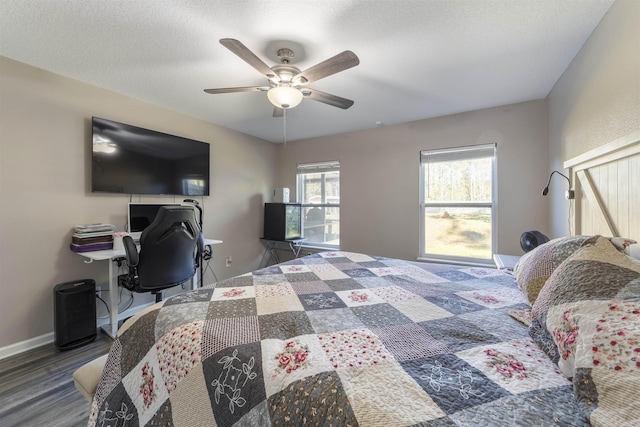 bedroom with a textured ceiling, dark hardwood / wood-style floors, and ceiling fan