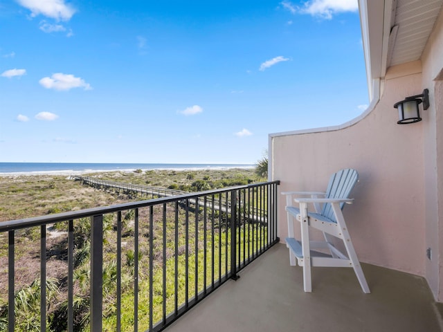 balcony featuring a water view and a beach view