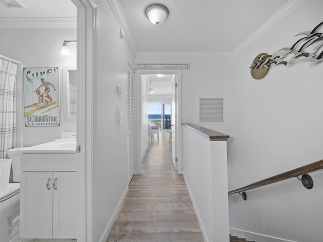 hall with crown molding, sink, and light wood-type flooring