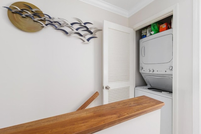 washroom featuring ornamental molding and stacked washer / dryer