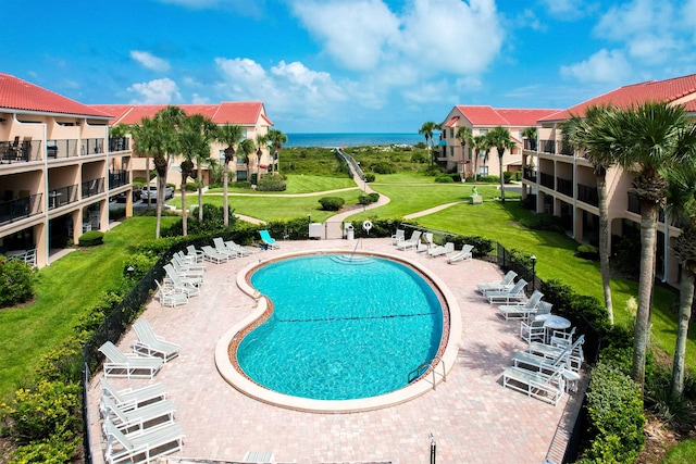 view of pool with a patio area and a water view