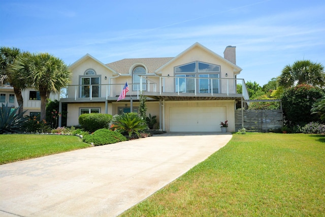 view of front of home featuring a balcony, a front yard, and a garage