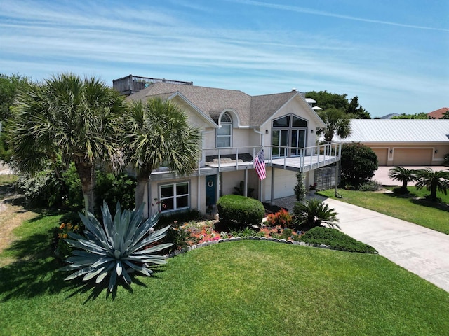 view of front of house featuring a balcony, a front lawn, and a garage