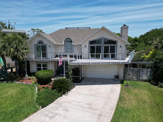 view of front of house with a front yard, a balcony, and a garage