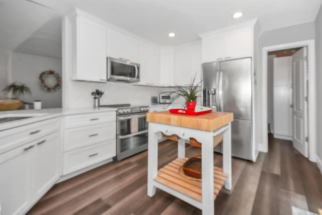 kitchen with white cabinets, stainless steel appliances, and dark wood-type flooring