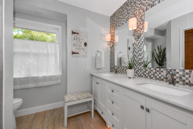 bathroom with toilet, hardwood / wood-style floors, tasteful backsplash, and vanity