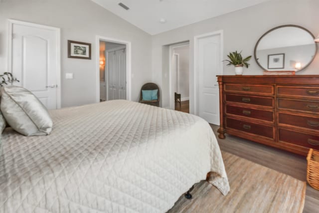 bedroom featuring lofted ceiling and wood-type flooring