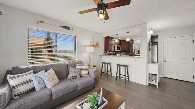 living room featuring a textured ceiling and ceiling fan