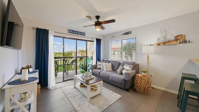 living room featuring ceiling fan and a textured ceiling