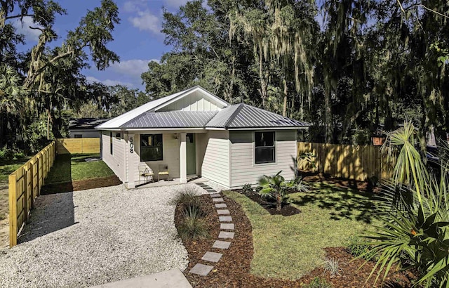 bungalow featuring covered porch and a front yard