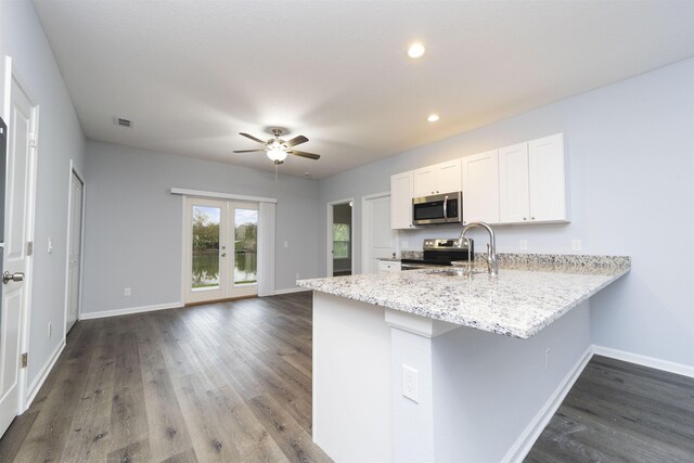 679 Coral Cir, Saint Augustine, FL 32080 - kitchen featuring stainless steel appliances, ceiling fan, a peninsula, dark wood finished floors, and white cabinets