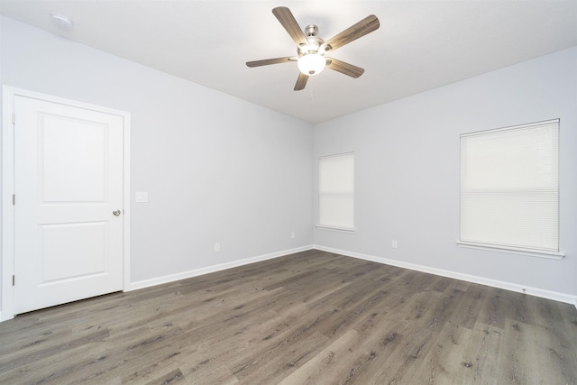 unfurnished room with ceiling fan and dark wood-type flooring