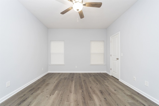 empty room with dark hardwood / wood-style floors and ceiling fan