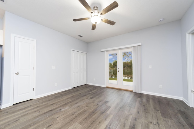 unfurnished bedroom featuring dark hardwood / wood-style flooring, ceiling fan, and french doors