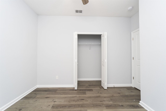 unfurnished bedroom with a closet, ceiling fan, and dark wood-type flooring