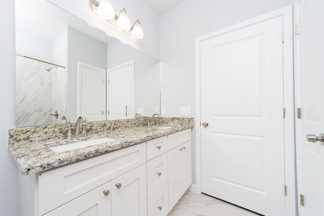 bathroom featuring a tile shower and vanity