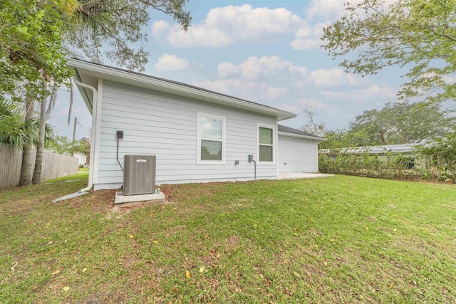 rear view of property with a yard, a patio, and central AC unit