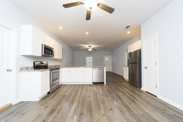 679 Coral Cir, Saint Augustine, FL 32080 - kitchen featuring appliances with stainless steel finishes, a ceiling fan, a peninsula, light wood-style floors, and recessed lighting