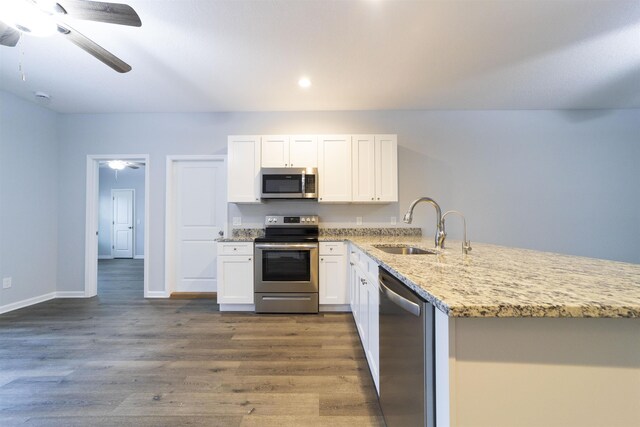 679 Coral Cir, Saint Augustine, FL 32080 - kitchen with stainless steel appliances, ceiling fan, light stone counters, white cabinetry, and dark wood-type flooring
